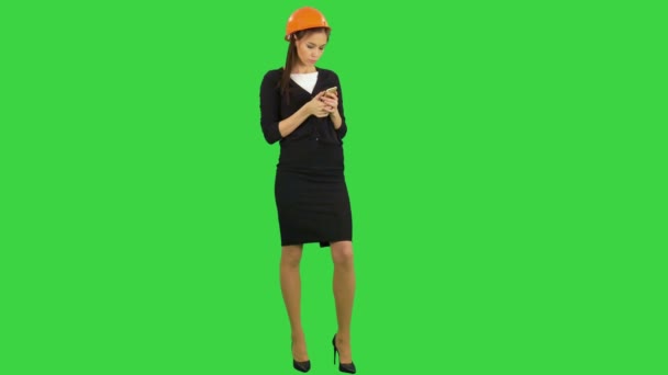 Bella ingegnere donna in hardhat utilizzando un cellulare su uno schermo verde, Chroma Key — Video Stock