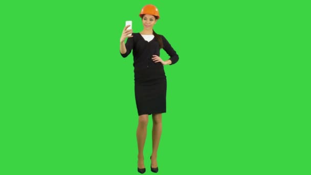 Jonge vrouwelijke architect in helm nemen van selfies op telefoon in een groen scherm, Chromakey — Stockvideo