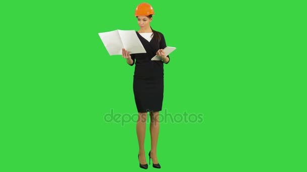 Female construction engineer in helmet holding blueprints and using tablet on a Green Screen, Chroma Key — Stock Video