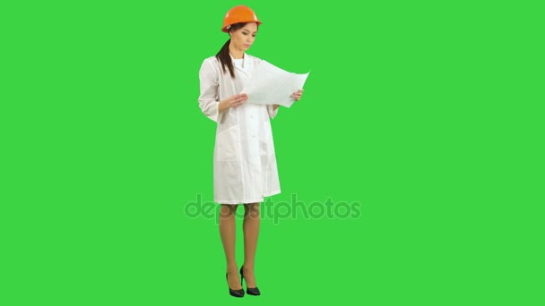 Giovane architetto donna che tiene cianografie e ispeziona la costruzione su uno schermo verde, Chroma Key — Video Stock