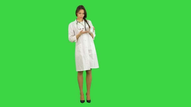 Doctora bastante femenina describiendo y anunciando píldoras para la cámara en una pantalla verde, Chroma Key — Vídeo de stock