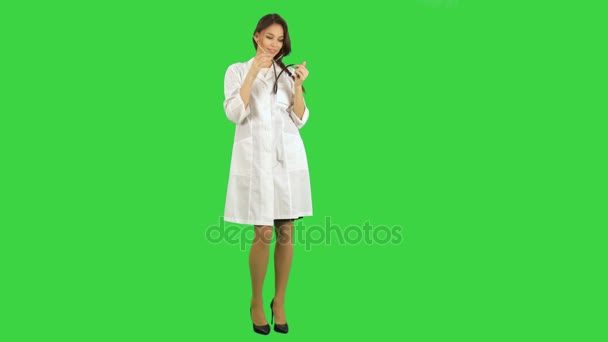 Funny female nurse playing with a stethoscope on a Green Screen, Chroma Key — Stock Video