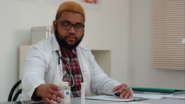 Afro-Américain travailleur médical masculin prescrivant des pilules — Video