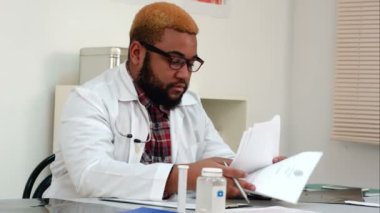 Onun masasında tıbbi evrak alseep düşen overworked erkek doktor