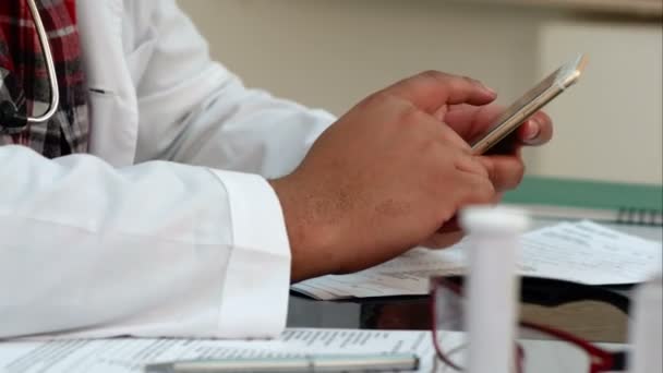 Мужские руки доктора пишут смс на смартфоне — стоковое видео