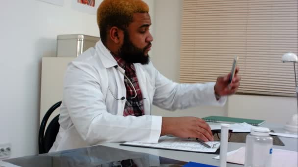 Médico masculino afroamericano tomando selfie y mostrando el pulgar hacia arriba — Vídeo de stock