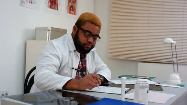 Afroamerican 남성 의사는 병원에서 긴 근무일 후 피곤 — 비디오