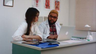 İki doktor bir şey laptop üzerinde tartışıyor
