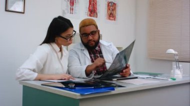 Kadın ve erkek doktorlar ofiste oturan xray görüntü incelenmesi