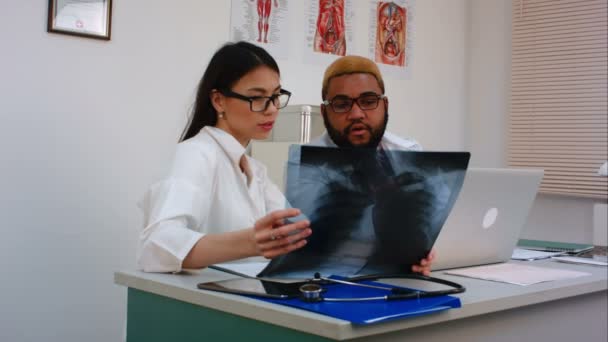 İki doktor bilgisayar kullanırken X-Ray görüntü tartışıyor — Stok video