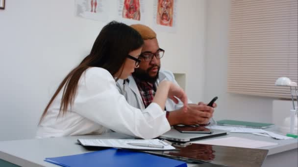 Médicos femeninos y masculinos discutiendo algo por teléfono — Vídeo de stock