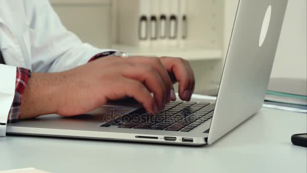 Hombre médico manos escribiendo en el teclado del ordenador portátil — Vídeo de stock