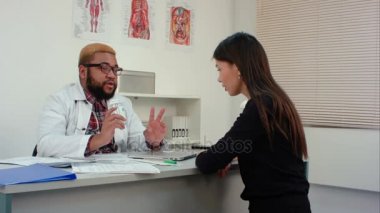 Bayan hasta ilaç reçete ve dozaj açıklayan bir doktor