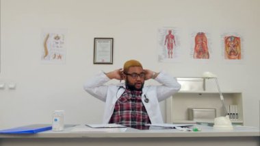 Yorgun genç doktor molası sırasında telefon görüşmesi yanıtlamaktan mutluluk