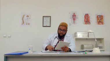 Afroamerican doktor ofisinde dijital tablet ile çalışma