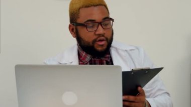 Doktor hasta üzerinden görüntülü görüşme için dizüstü bilgisayarda Xray sonuçları açıklayan