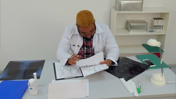 Médecin épuisé tombant également sur les papiers médicaux à son bureau 