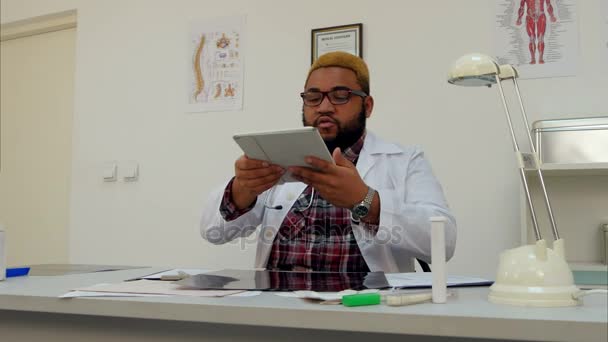 Afryki amerykański lekarz mężczyzna biorąc zdjęcie xray wyników na jego tabletu — Wideo stockowe