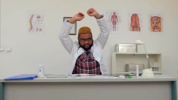 Stanco medico di sesso maschile stretching ed esercizio dopo una lunga giornata di lavoro alla sua scrivania — Video Stock
