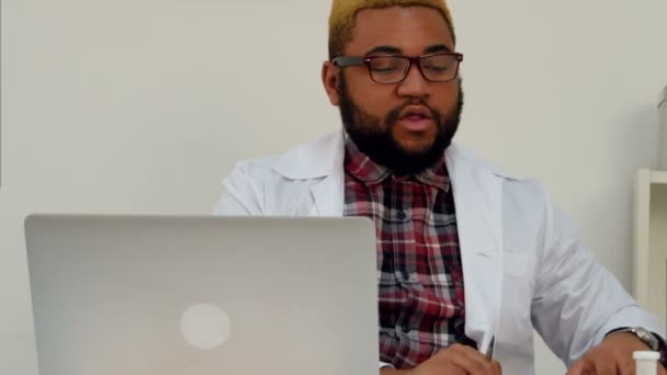 Afroamerican male doctor discussing brain xray image with patient on Skype — Stock Video