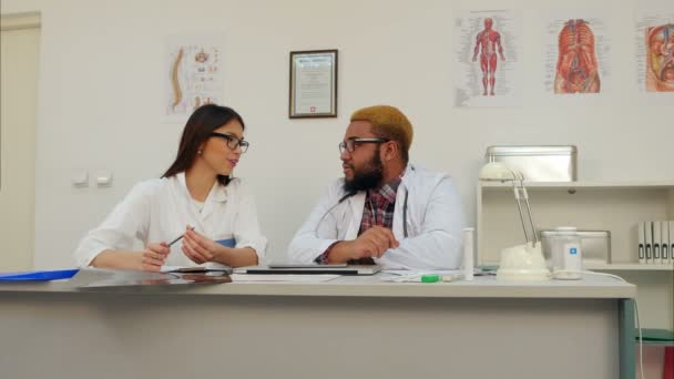 Dos médicos alegres discutiendo en la oficina — Vídeos de Stock