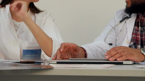 Female and male doctor hands at the desk with laptop and papers — Stock Video