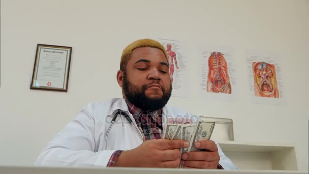 Afroamerican male doctor counting his salary in cash — Stock Video