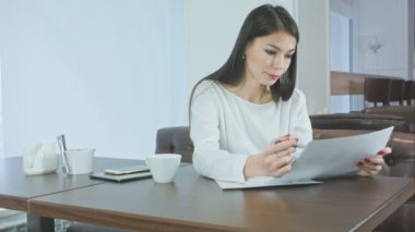 Genç kadın cafede oturan Proje raporu hazırlanıyor meşgul