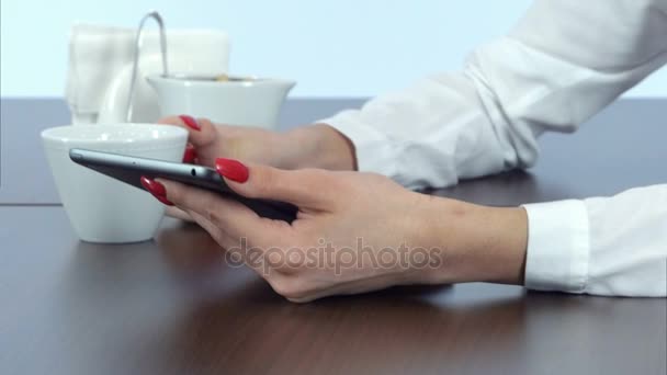 Female hands using tablet and holding coffee cup — Stock Video