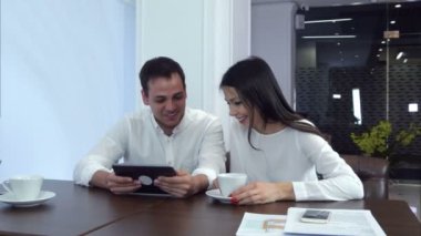 Genç çift onların öğle yemeği için bekleyen tablet komik bir şey gülüyorsun