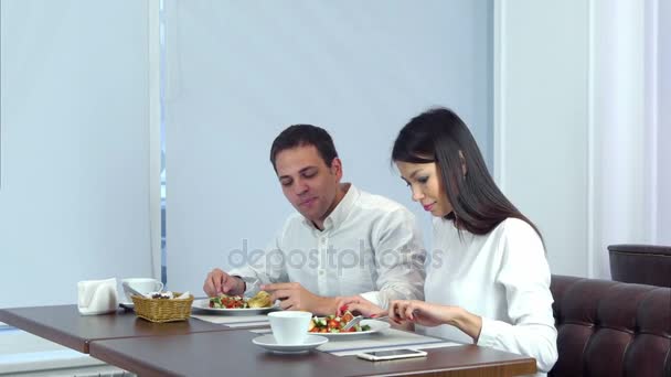 Fiatal pár élvezi a kávézóban ebéd ha több felszolgáló pincér — Stock videók