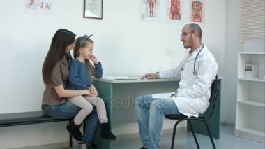 Çocuk doktoru Doktor muayene çocuk, annesi holding babygirl kucağında iken