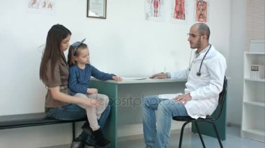 Genç anne ve erkek çocuk doktoru ile randevu sahip şirin küçük kızı