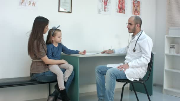 Young mother and her cute little girl having appointment with male pediatrician — Stock Video