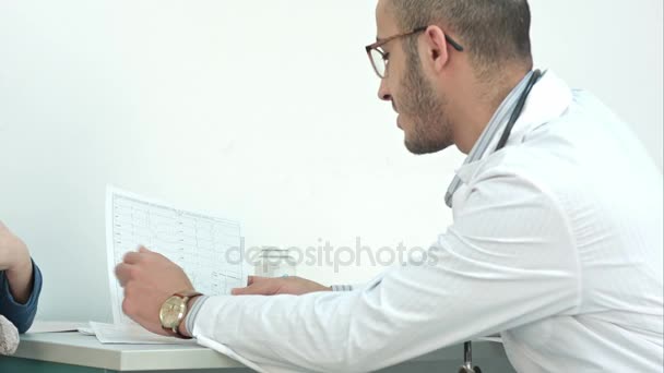 Smiling doctor explaining diagnostics results to his patient — Stock Video