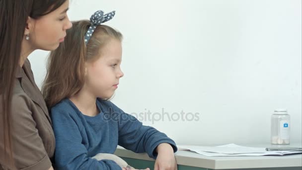 Маленька дівчинка має огляд горла з депресією язика від лікаря-чоловіка — стокове відео