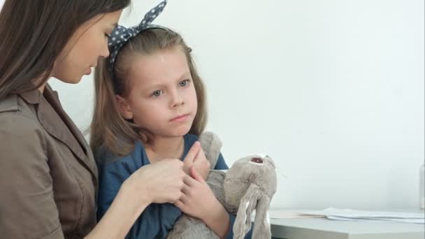 Mother giving thermometer back to doctor while her daughter playing with bunny — Stock Video