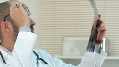 Genç erkek doktor Xray görüntü inceleyerek konsantre