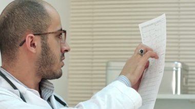 Genç erkek doktor kardiyogram arıyorsunuz