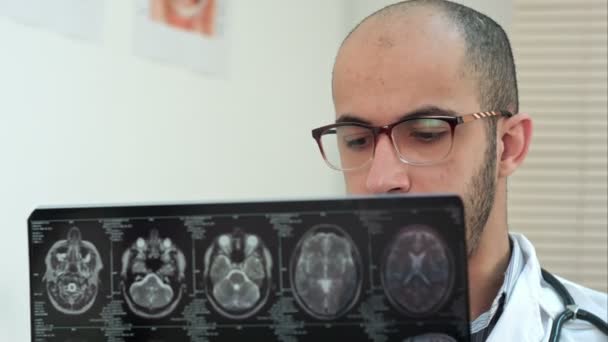 Мужчина-рентгенолог, изучающий компьютерную томографию мозга — стоковое видео