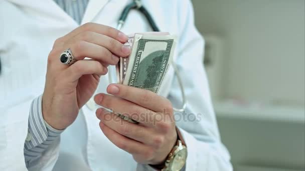 Médico varón contando dinero y poniéndolo en su bolsillo — Vídeo de stock