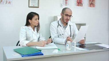 Kadın onun stajyer kardiyogram o notlar sırasında okumak nasıl gösteren doktor