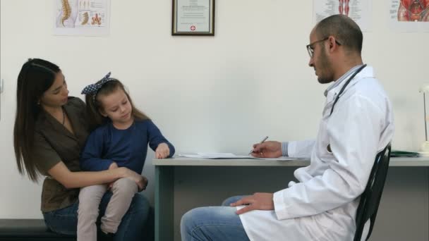 Joven madre y su linda niña en el pediatra — Vídeo de stock