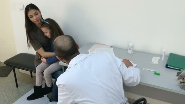 Lékař pediatr rozveselit malá holka pacienta s bunny toy — Stock video