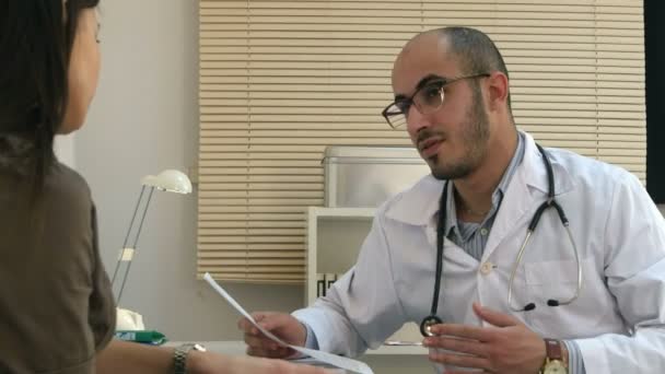 Médico árabe masculino explicando cardiograma al paciente femenino — Vídeos de Stock