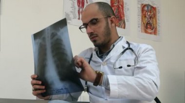 Genç erkek doktor göğüs xray görüntü inceleyerek konsantre