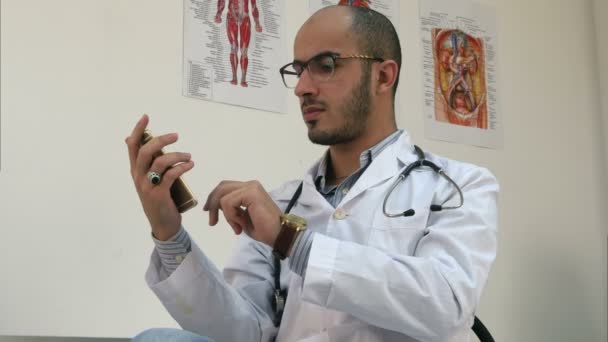 Bir akıllı telefon üzerinde ciddi erkek doktor manifatura — Stok video