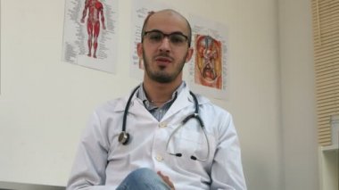 Kameraya konuşurken stetoskop ile olumlu erkek Arap doktor