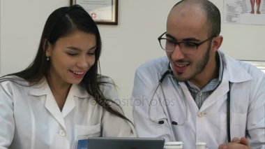 İki tablet üzerinde komik bir şey bakıyor ve gülüyor doktorlar