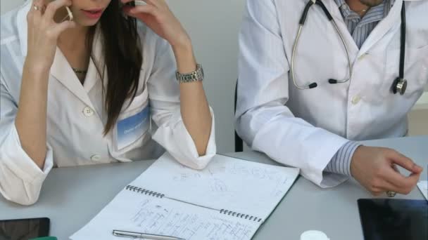 Asistente femenina hablando por teléfono pidiendo consejo al médico masculino — Vídeos de Stock